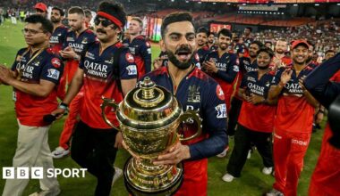 Royal Challengers Bengaluru's Virat Kohli (C), along with his teammates, takes a victory lap around the field as he celebrates with the trophy after winning the Indian Premier League (IPL) Twenty20 final cricket match against Punjab Kings at the Narendra Modi Stadium in Ahmedabad