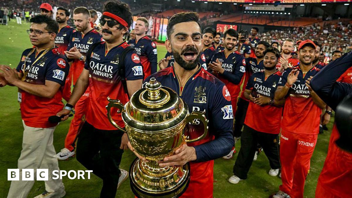 Royal Challengers Bengaluru's Virat Kohli (C), along with his teammates, takes a victory lap around the field as he celebrates with the trophy after winning the Indian Premier League (IPL) Twenty20 final cricket match against Punjab Kings at the Narendra Modi Stadium in Ahmedabad