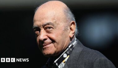 Mohamed Al Fayed is pictured at a football match wearing a grey suit jacket and a patterned black, grey and yellow shirt. He is balding with grey hair to the sides. At the time he was the Fulham chairman and is pictured ahead of the Barclays Premier League match between Fulham and Wolverhampton Wanderers at Craven Cottage on April 17, 2010 in London.