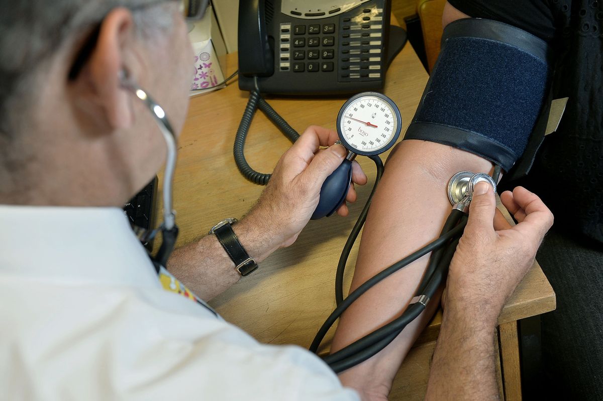 A doctor tests a patient's blood pressure