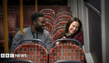 Paapa Essiedu and Siobhán Cullen sitting on the bus and laughing