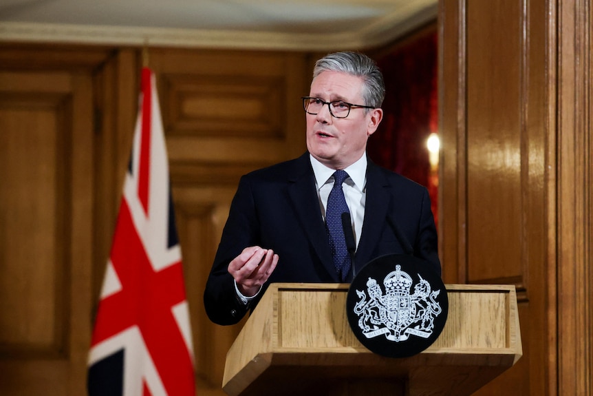 Keir Starmer giving a press conference in Downing Street with the British flag behind him.