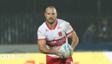 Karl Lawton carrying the ball in both hands but slightly towards his left-hand side playing for Hull KR