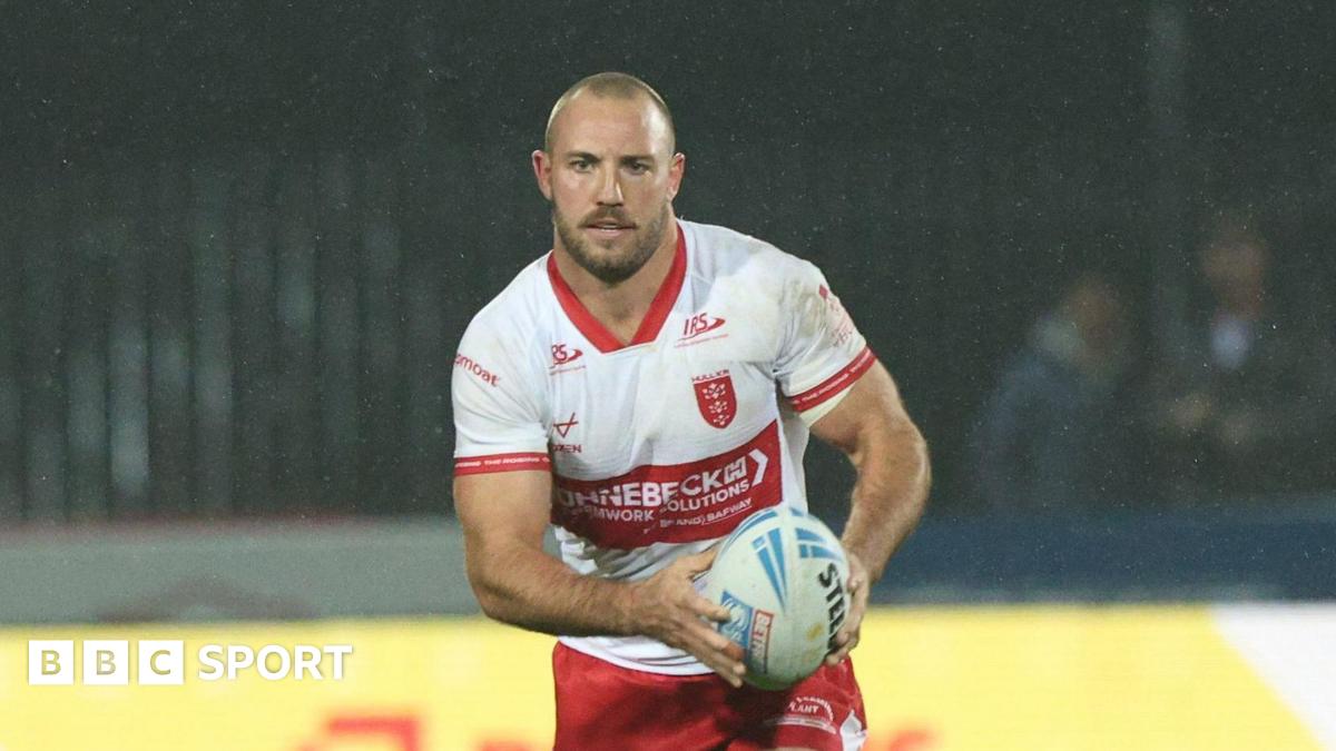 Karl Lawton carrying the ball in both hands but slightly towards his left-hand side playing for Hull KR