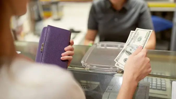 a woman holding cash and her wallet