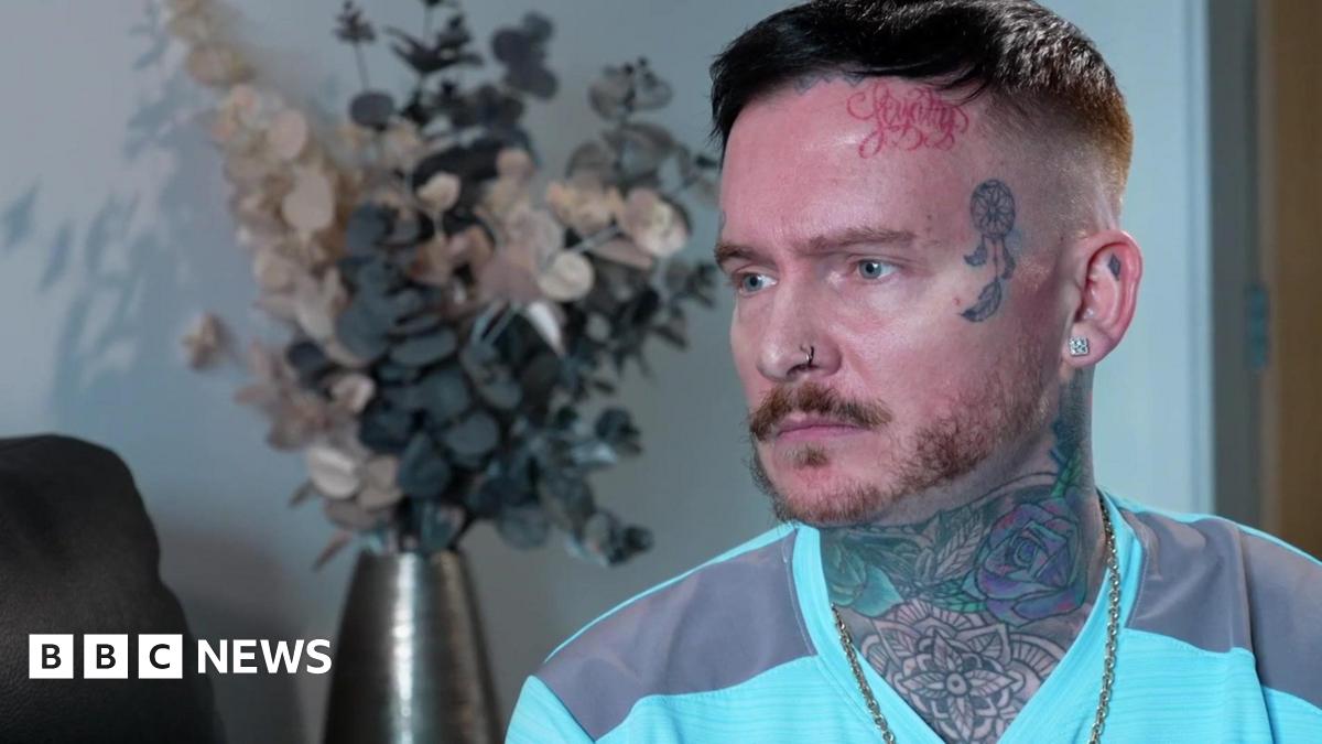 Andrew Dearden, wearing a green T-shirt with a full neck tattoo and an animal tattoo on his temple, speaks to the BBC