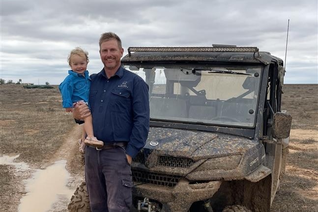 Man smiling in muddy field