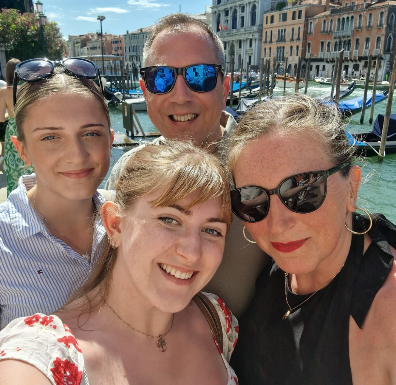 The Kenny family, Juliette, Michael, Rebecca, and Florence, smiling with a canal and buildings in the background.
