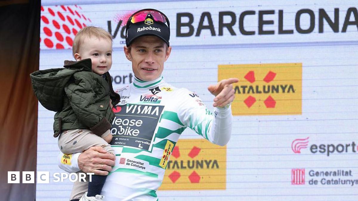 Jonas Vingegaard holds his young son on the podium after his victory