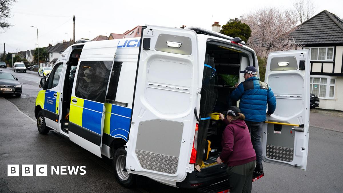 Four students walking side-by-side wearing blue face masks. Two boys on the left of the image, two girls on the right.
