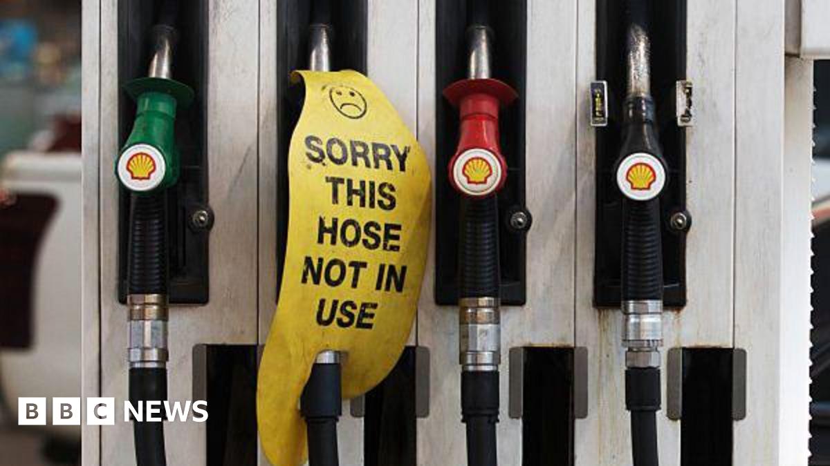 Petrol dispensers at a petrol station. One has a sign reading "sorry this hose is not in use".