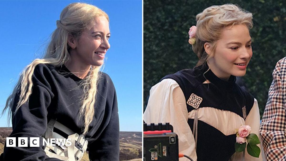 Jacob Elordi in a black suit as Heathcliff and Margot Robbie as Cathy in a white and red PVC dress