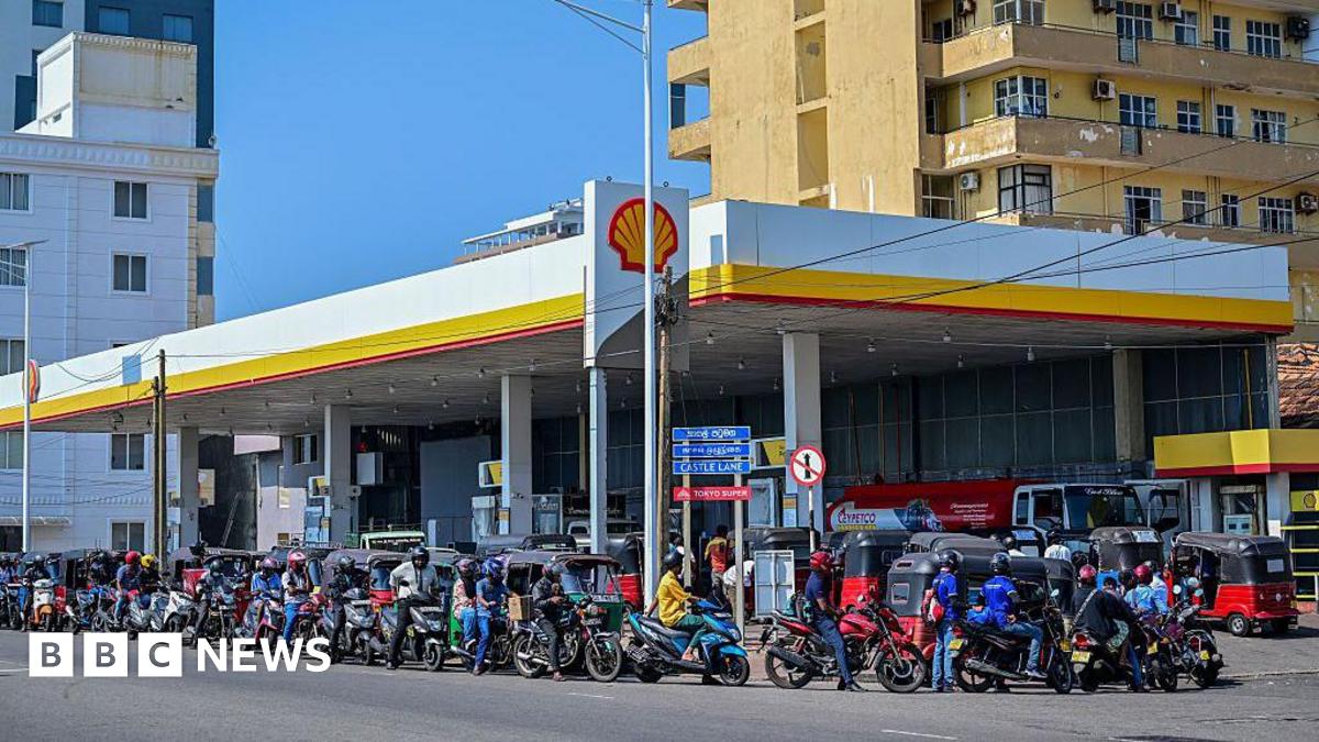 Motorists wait in a queue to refuel their vehicles at a filling station in Wellawatte on the outskirts of Colombo