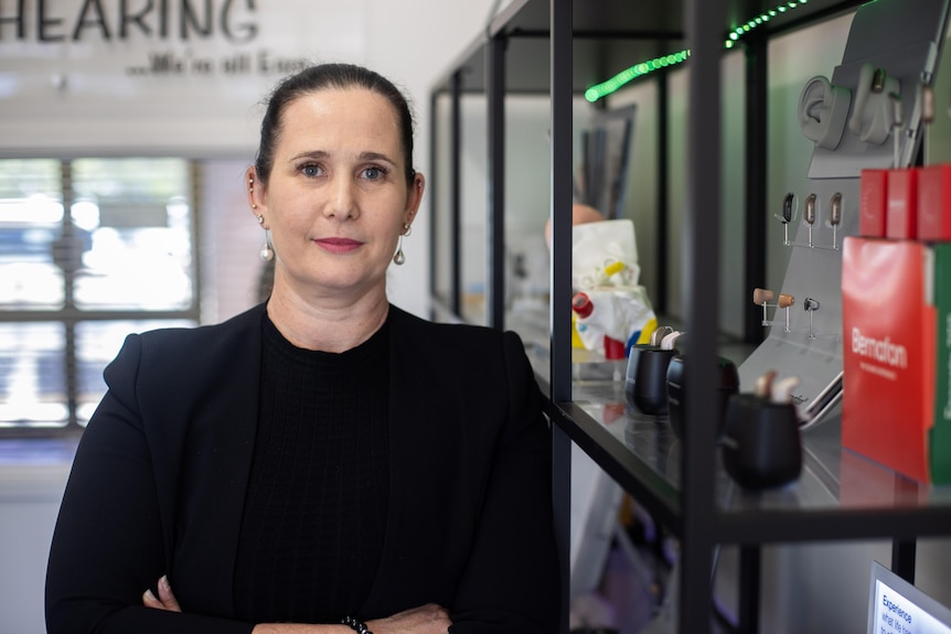A woman dressed in black with her arms crossed. 