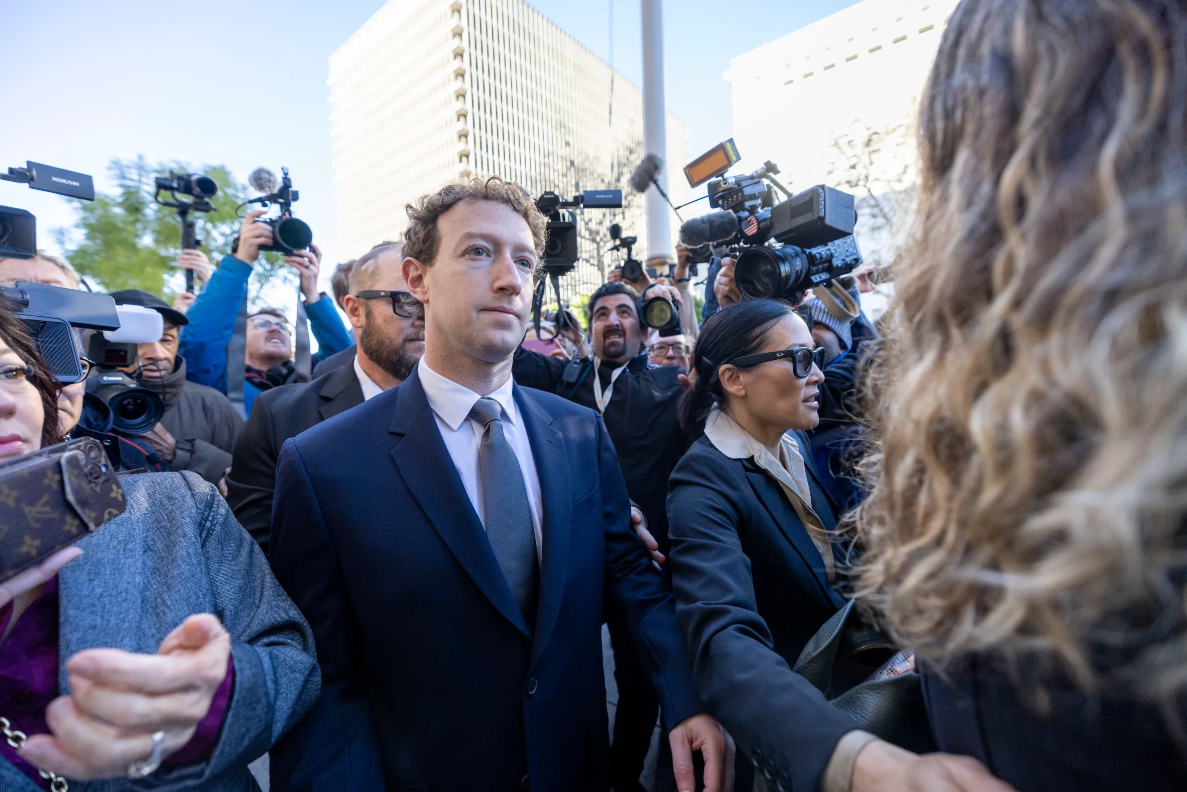 Meta CEO Mark Zuckerberg is surrounded by a crowd of reporters and photographers while arriving at a Los Angeles courthouse.