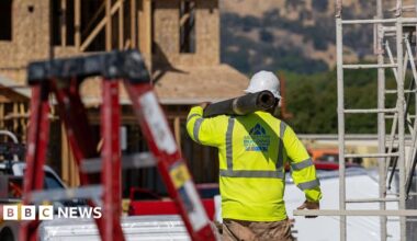 A worker carries materials outside of a new home under construction at the Lilac Ridge community by Lennar Homes in Vacaville, California, US, on Wednesday, Oct. 8, 2025.