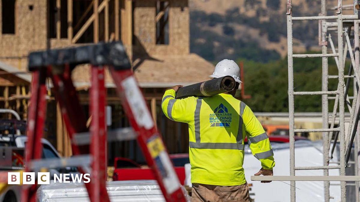 A worker carries materials outside of a new home under construction at the Lilac Ridge community by Lennar Homes in Vacaville, California, US, on Wednesday, Oct. 8, 2025.