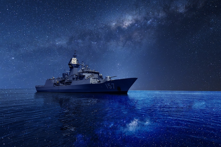 Ship at sea at night with the stars above and the reflected in the sea below.