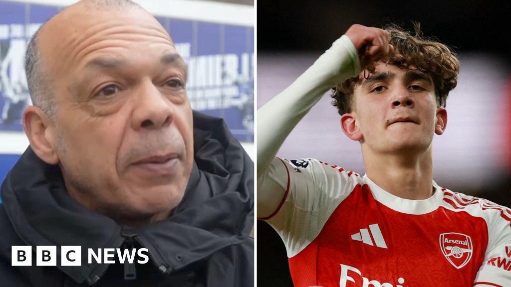 Jason Dozzell is wearing a dark coat standing outside the Ipswich Town football stadium. Max Dowman is on the pitch wearing a red Arsenal shirt.