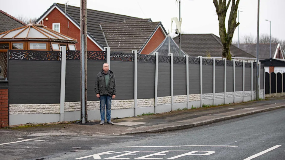 David Hopwood stands by his fence in Bolton, Greater Manchester. 