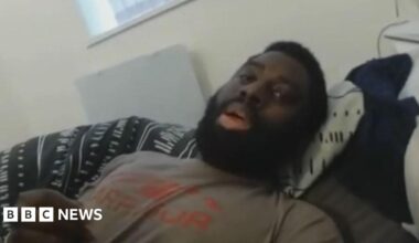 Valdo Calocane in front of a police car with three police officers who have their faces blurred out.