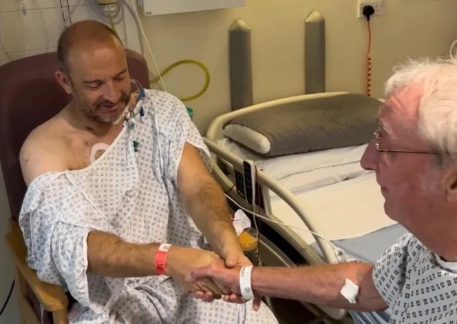 Ian Tonks and Graham Sisson shaking hands before surgery.