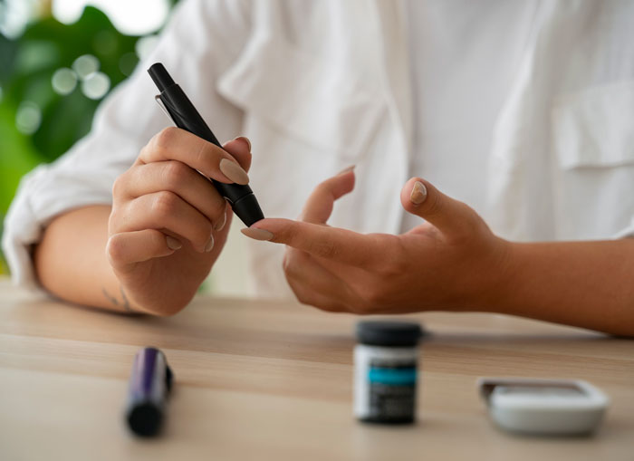 Person using a blood glucose meter to check blood sugar, illustrating diseases doctors say should scare people more