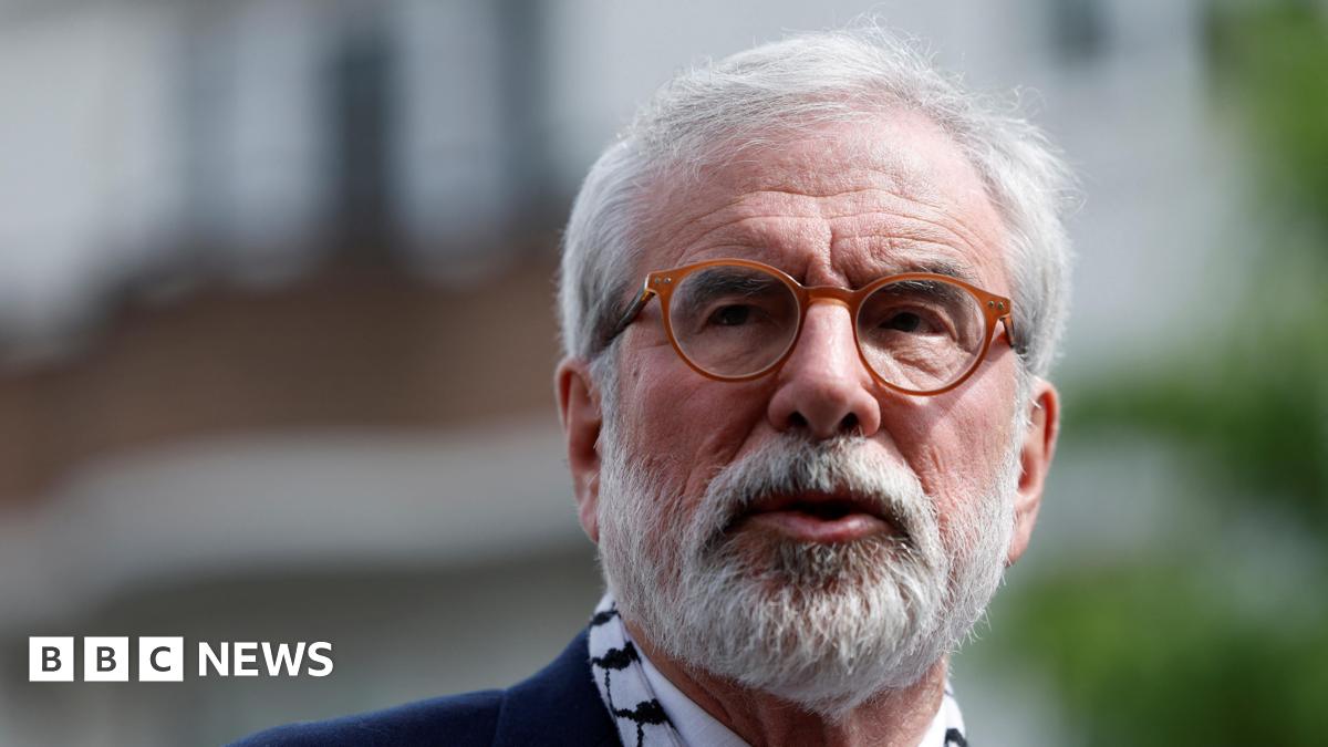 A man with a white beard and brown rimmed glasses looks off camera. All that is visible is his face - it is an up close picture.