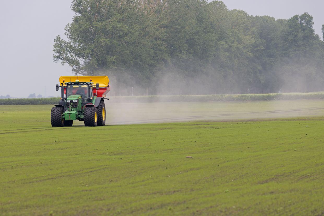 Shot of a tractor travelling across a green field.