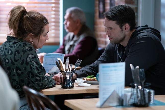 Vicki and Mark Fowler Jr talk over a table in the café in EastEnders
