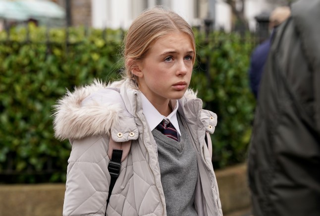 Lexi Pearce standing in Walford looking worried in EastEnders.