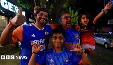 Two men and two children - of which three are wearing the blue jersey of the India men's cricket team - celebrate India's victory in the T20 cricket World Cup in the southern city of Bangalore on 8 March 2026.