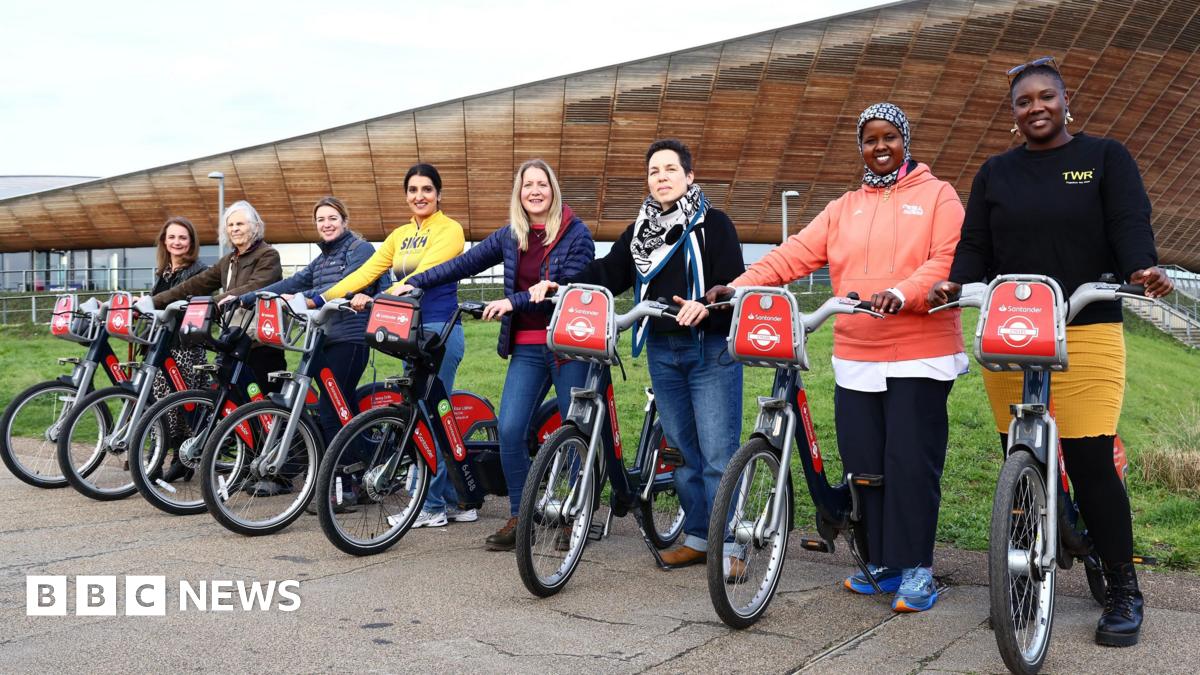 Eight women each holding a Santander TFL hire bike, which has been named after them for being an inspirational women in the cycling community. The women are all smiling
