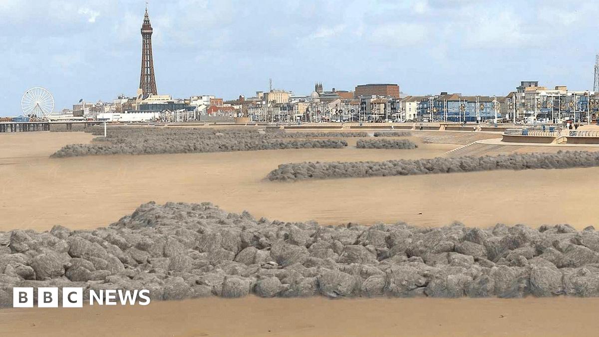 Visualisation of rock headlands along the beach. They are long stretches of grey rocks edging from the steps to the beach towards the sea. Blackpool's coastline can be seen in the distance in the background with the tower to the left