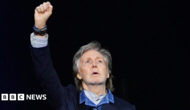 Paul McCartney raises his hand to the air during a concert at the O2 Arena in December 2024