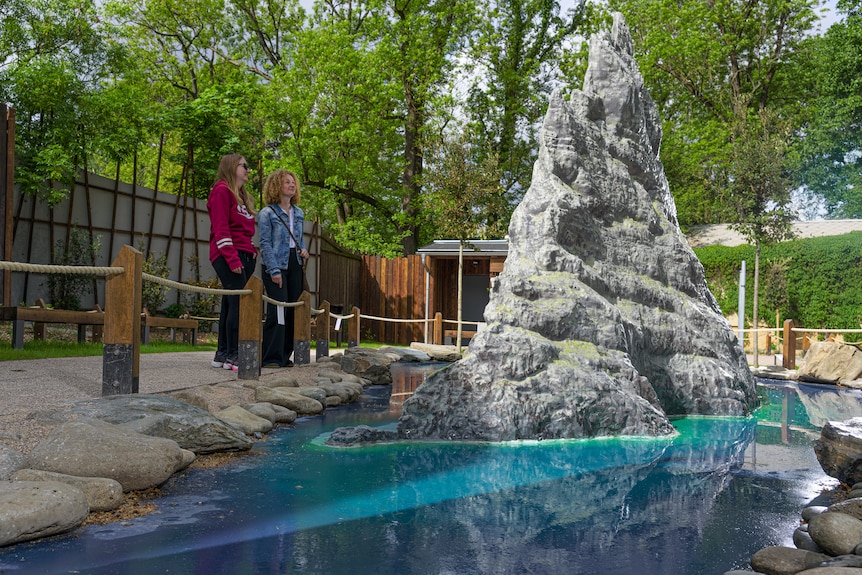 zoo visitors look at model of volcanic island spire