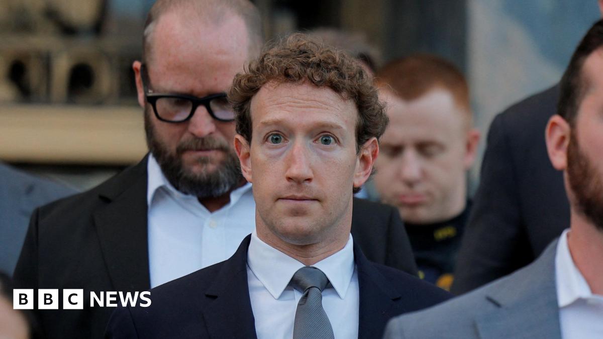 Mark Zuckerberg walking down the grey stone steps of a Los Angeles court house wearing a navy suit blazer, grey neck tie and white shirt.