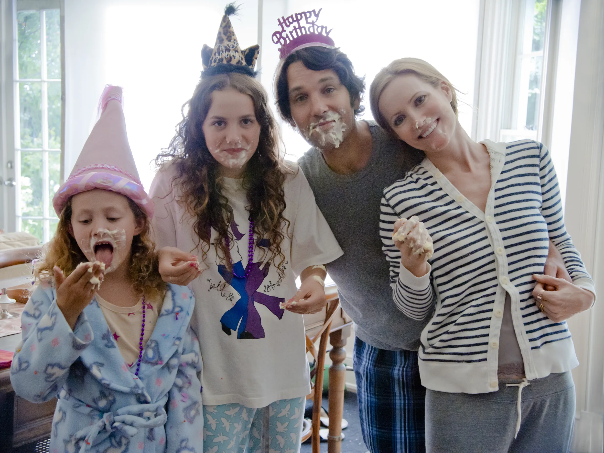 Charlotte, Sadie, Pete, and Debbie from the movie "This is 40" with frosting on their faces and wearing birthday hats.