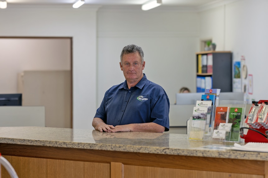 Middle aged man stands behind service counter