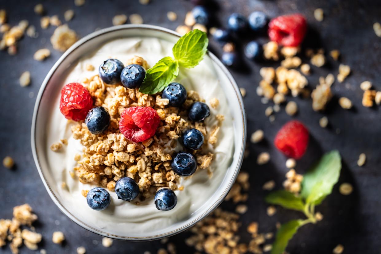 Yogurt bowl with muesli, raspberries and blueberries - Top of view. A healthy breakfast or snack, rich in protein, fiber and calcium. Healthy diet and lifestyle concept.