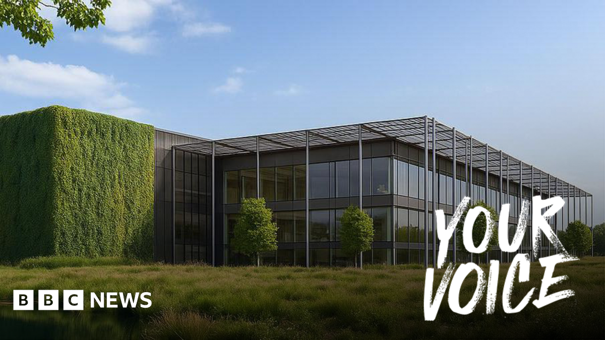 A large data centre building. It is mostly glass windows with trees dotted around in front of the building