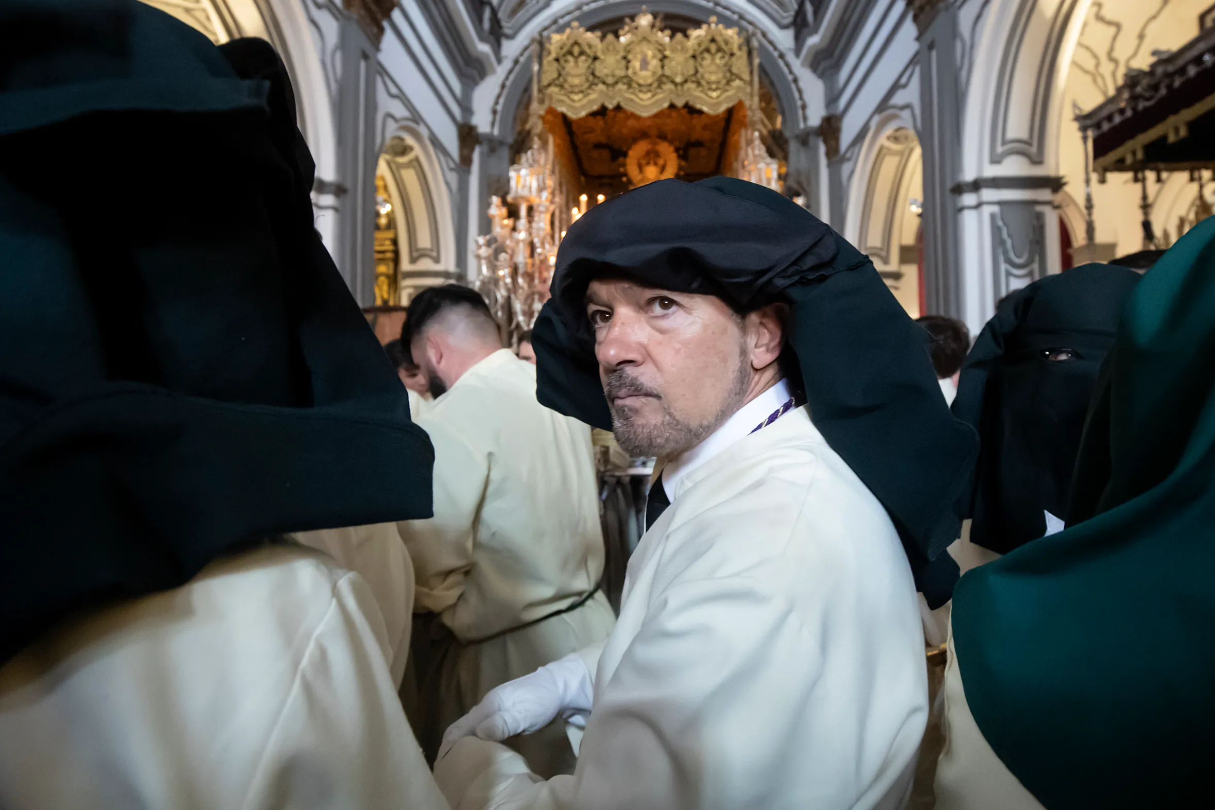 Antonio Banderas, dressed in a white robe and dark hood, attends an Easter procession in Malaga.