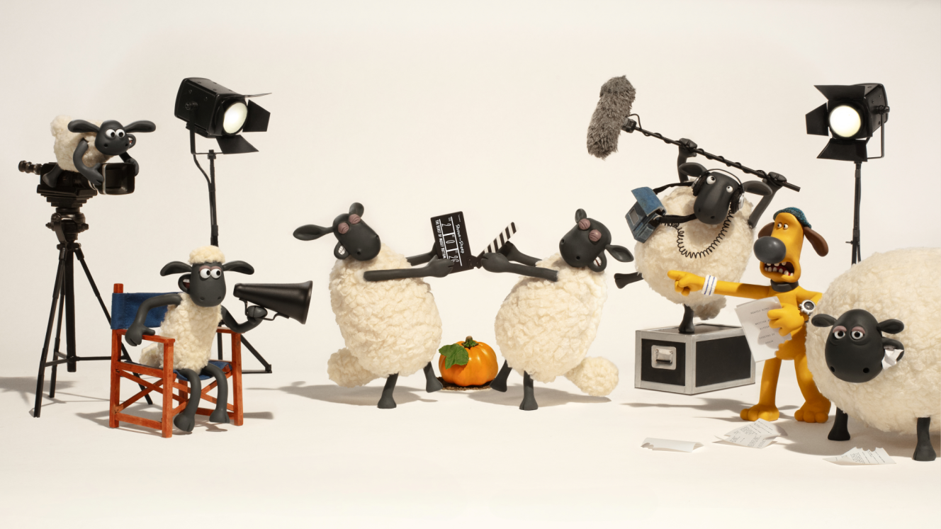 Illustration of Shaun the Sheep and other characters from the series filming a movie, with a pumpkin in the middle.