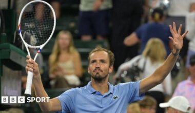 Daniil Medvedev holds up a tennis racquet