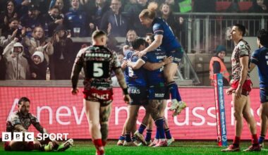 Wakefield players embrace Jayden Myers after his try early in the second half against Leigh