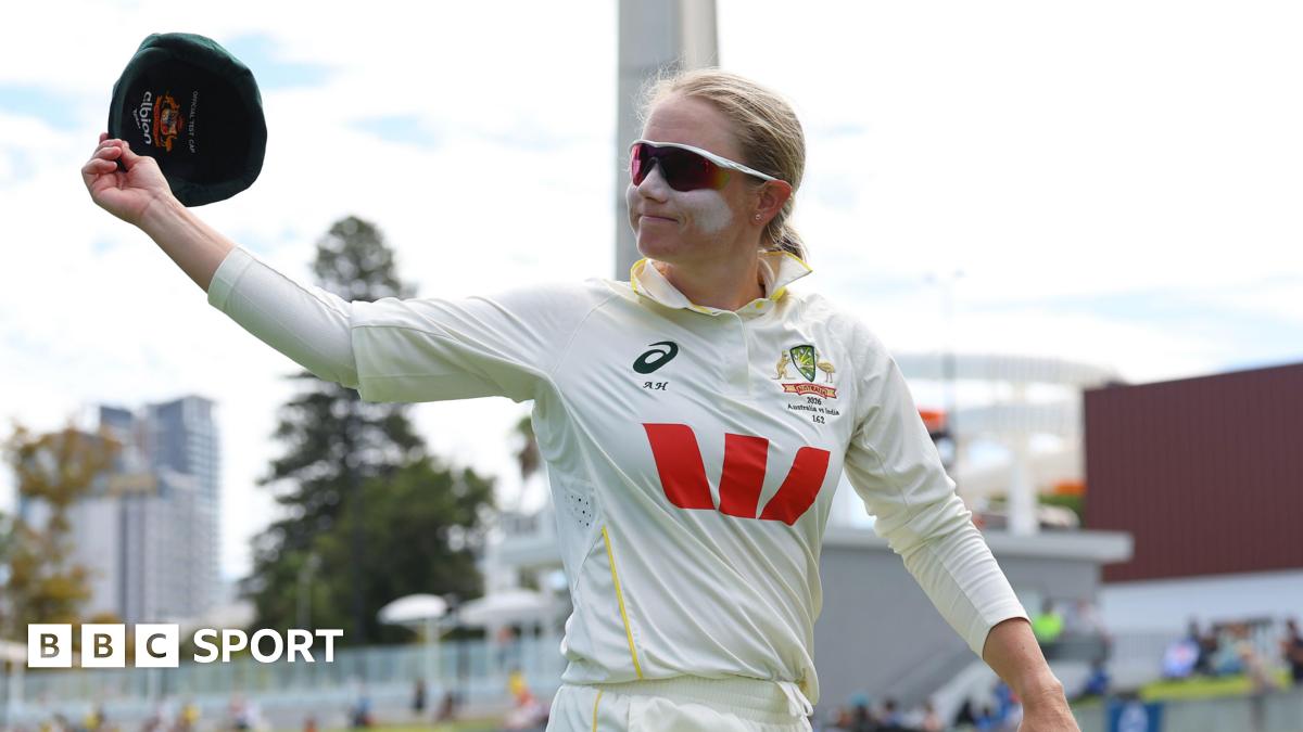 Australia captain Alyssa Healy raises her cap in the air as she walks off the field