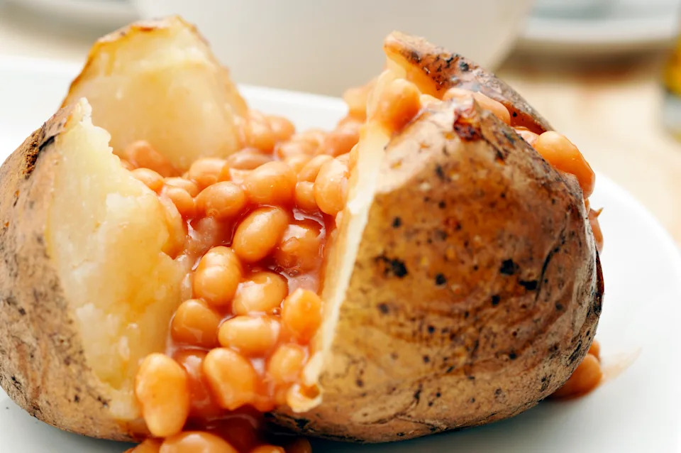 Close-up shot of baked jacket potato filled with baked beans.
