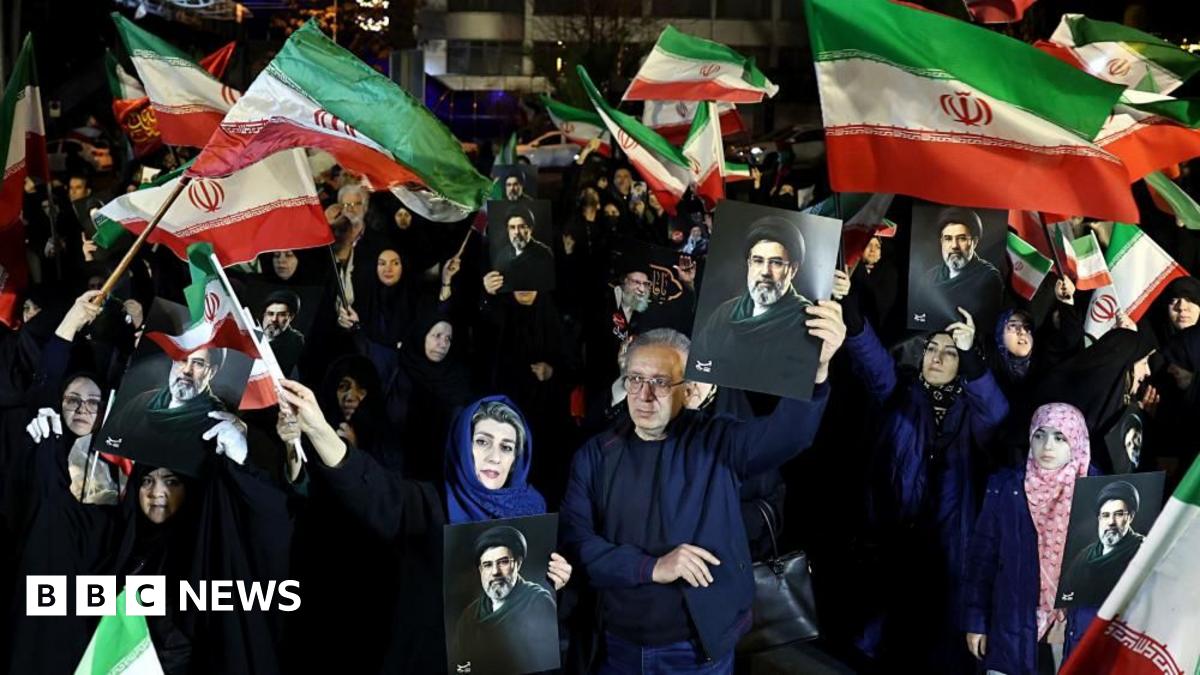 Iranians wave national flags and hold photos of the country's new Supreme Leader Mojtaba Khamenei at a rally in Tehran