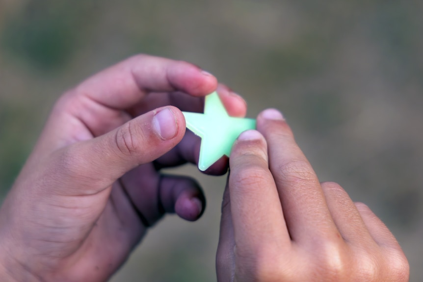 A child's hands holding a glow-in-the-dark star.