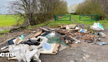 A pile of mixed and burnt rubbish has been fly-tipped and left down a country lane.